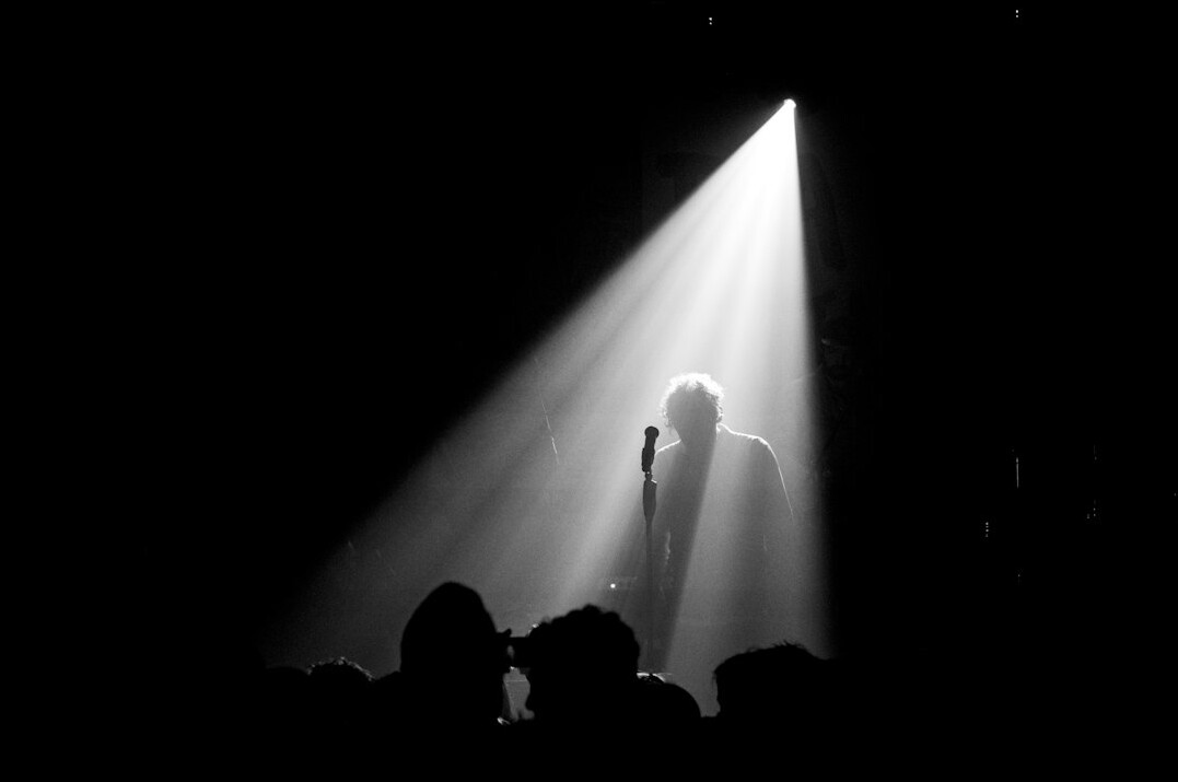 Microphone stand and spotlight set up on an empty small stage