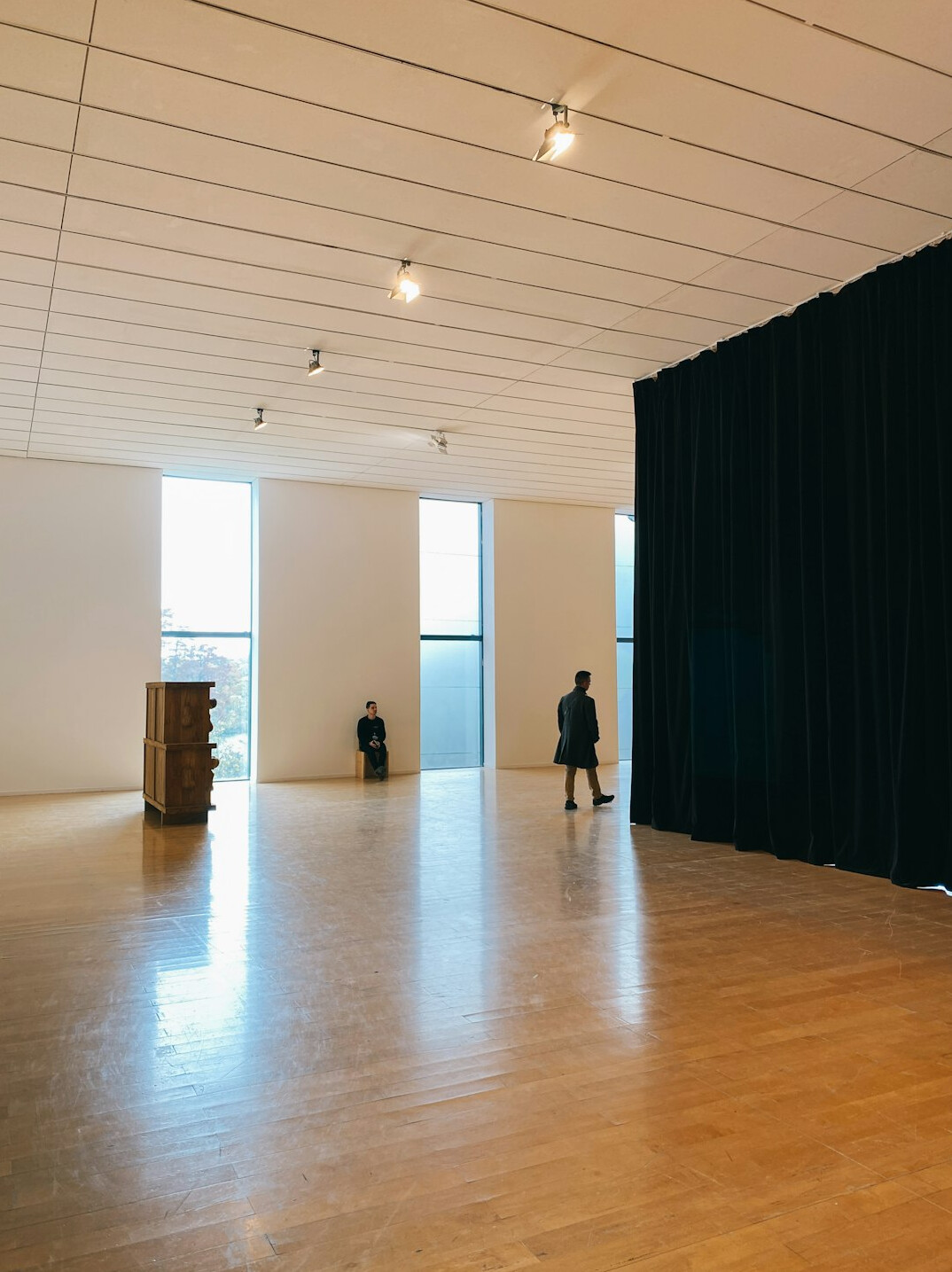Empty theatre rehearsal hall with warm lighting and rows of seats